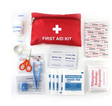 First aid kit with various supplies on a white background