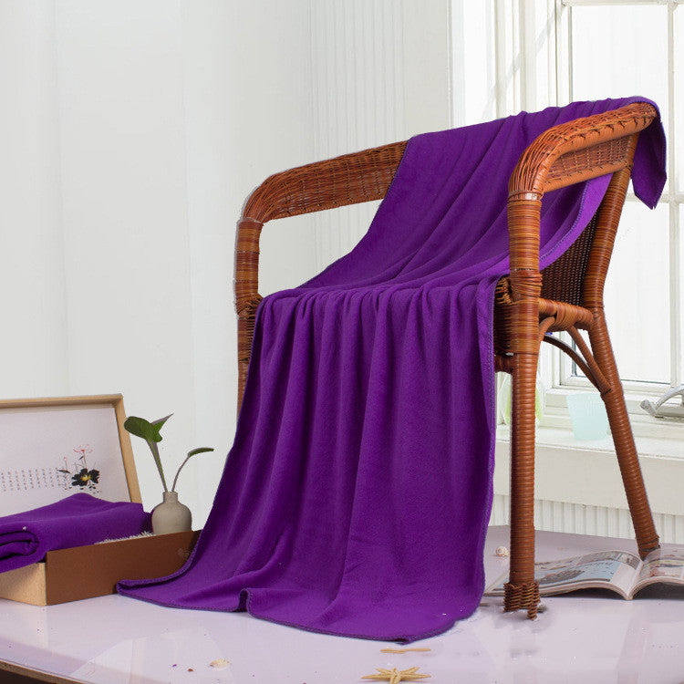Purple soft microfiber towel draped over a wicker chair.