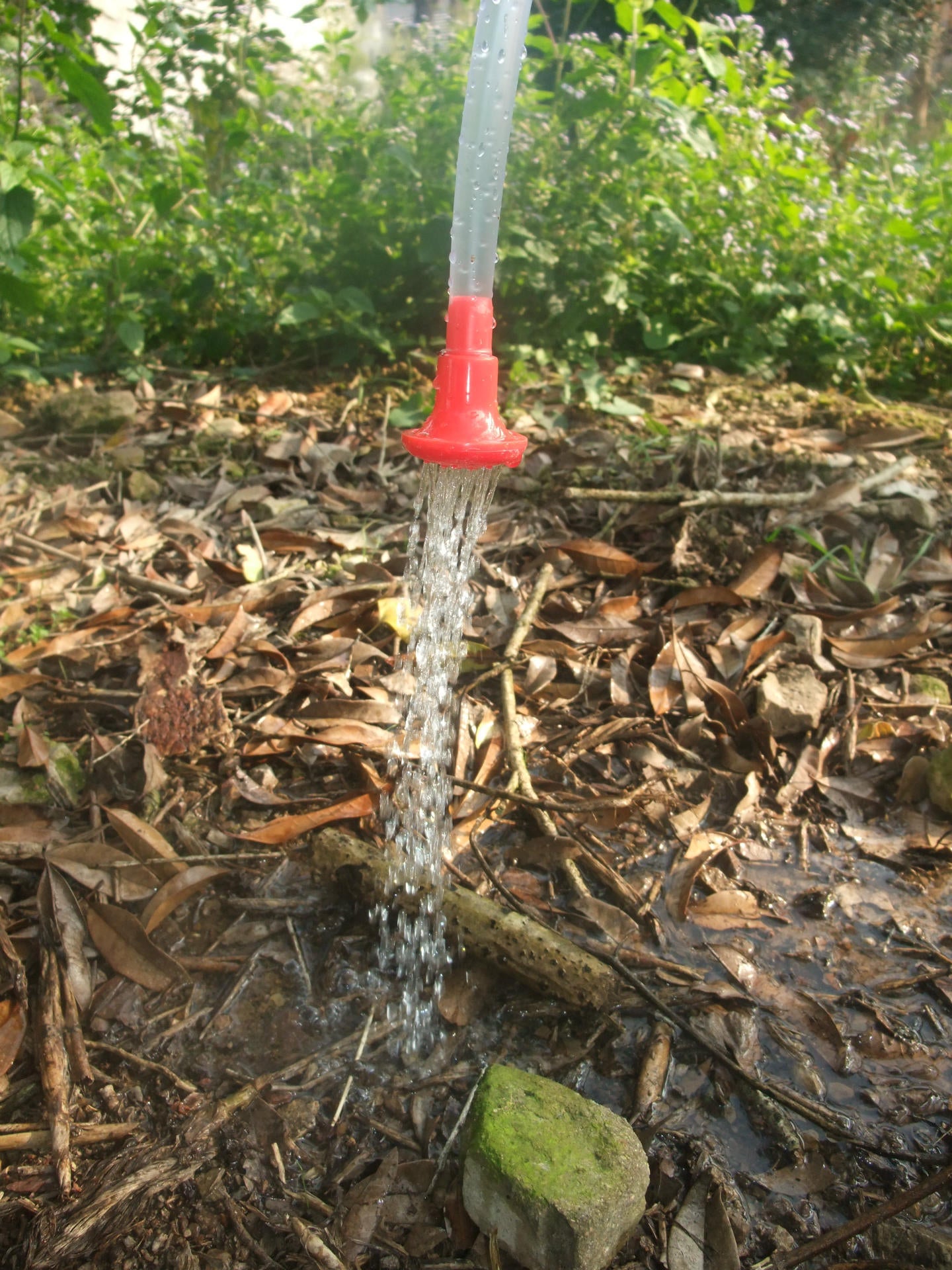portable shower water bag hose nozzle spraying water.