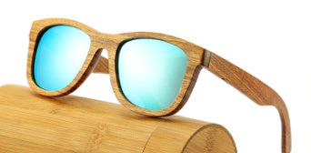 Wooden-framed sunglasses with blue-tinted lenses on a wooden surface