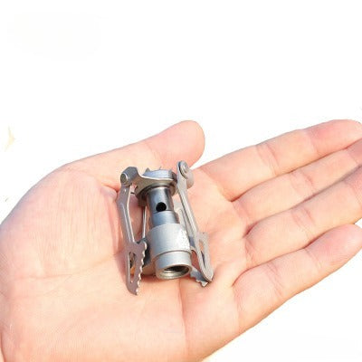 compact titanium burner UK view held in a hand on a white background