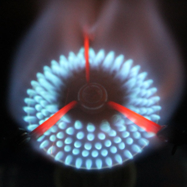 Close-up of a gas stove burner with blue and red flames Australia