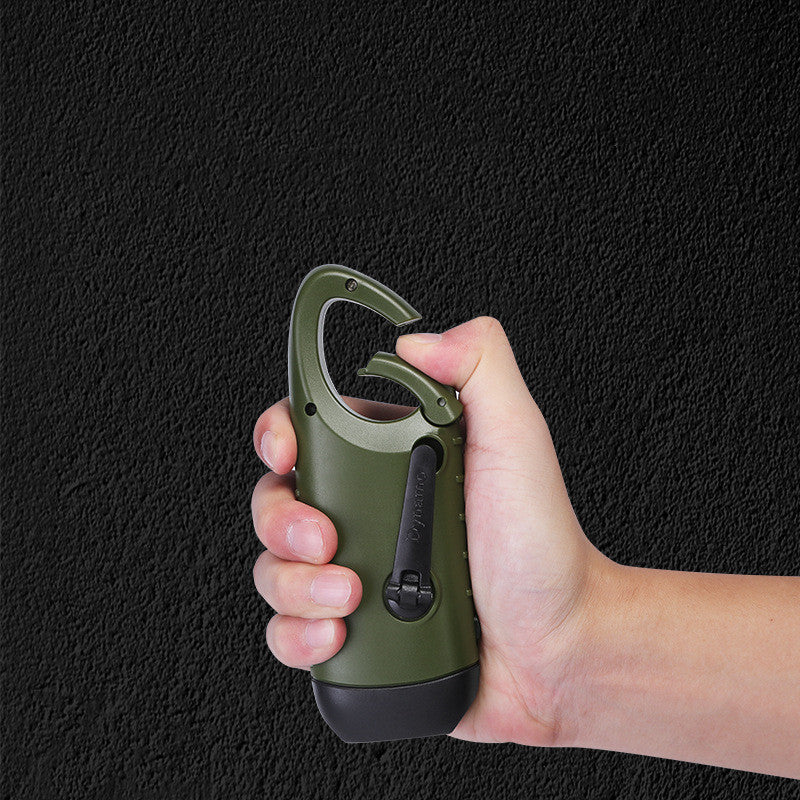 compact solar flashlight olive green Canada outdoors with hand holding a green carabiner