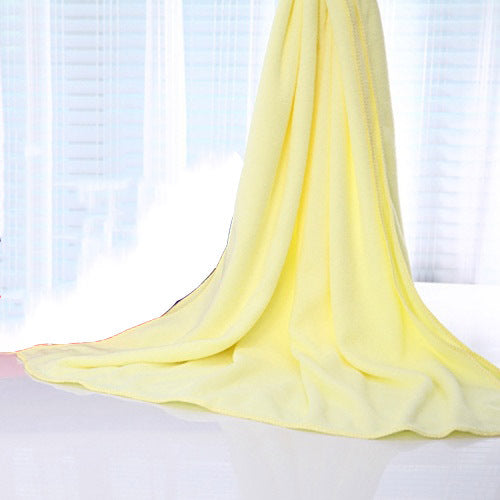 Yellow nano microfiber towel draped over a wicker chair  UK beach gear